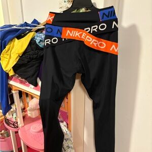 Nike pro women’s black leggings with orange and royal blue elastic cris cross